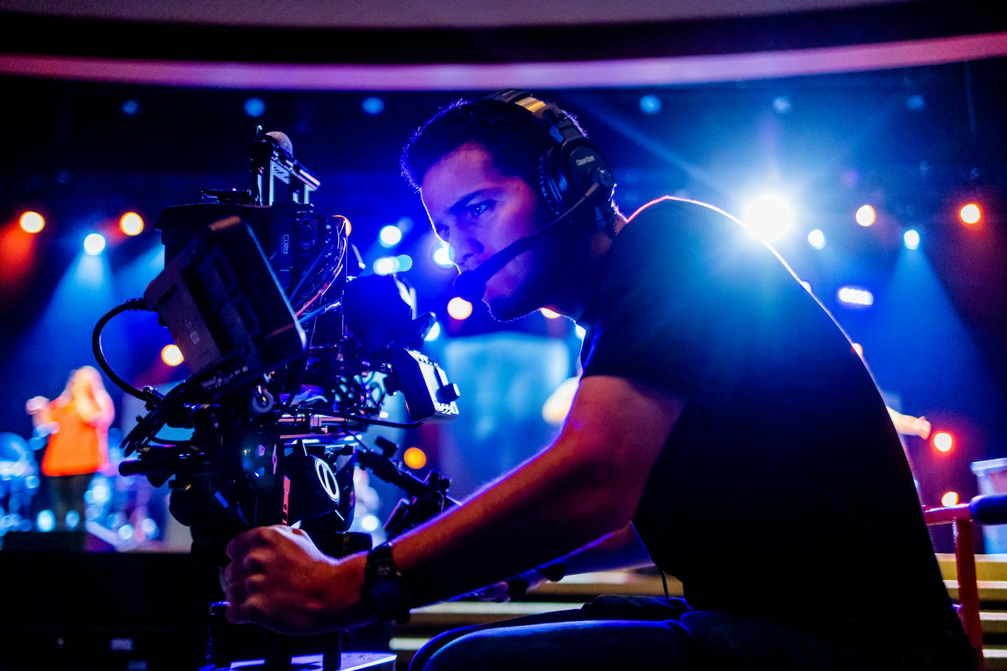 Focused Cameraman Using Advanced Equipment At A